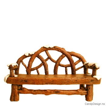 Benk i grener med snø